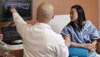 Radiologist sits and explainsresults to patient during Musculoskeletal Ultrasound.